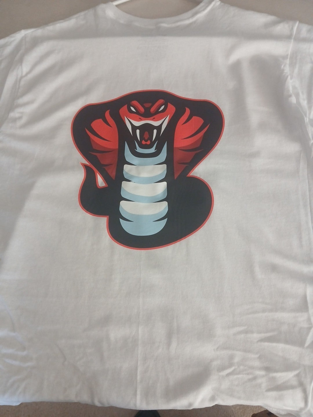 Venomous Volare white crew neck t-shirt featuring a bold red and black cobra graphic on the back